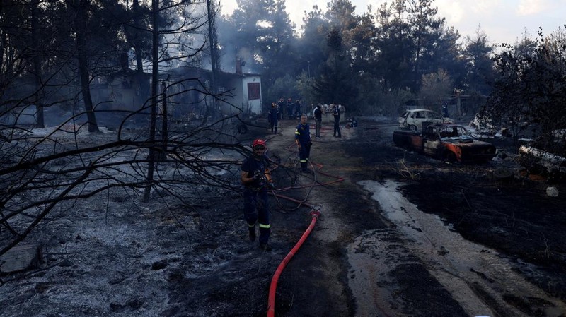 Petugas pemadam kebakaran berupaya memadamkan kebakaran hutan di dekat sebuah rumah yang terbakar di dekat desa Liti, Thessaloniki, Yunani, 30 Juni 2026.