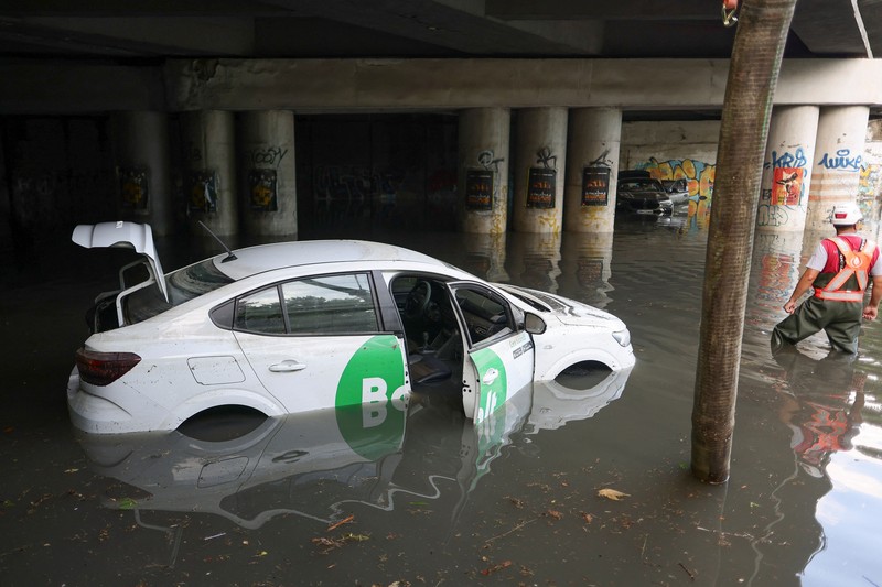 Para pekerja menyaksikan air hujan dipompa keluar dari terowongan kereta api yang tergenang banjir di bagian utara Bukares, Rumania, 1 Juli 2026. (Inquam Photos/Octav Ganea via REUTERS)