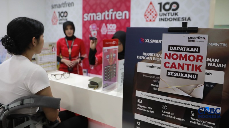 Seorang pengunjung melakukan sistem registrasi pelanggan layanan telekomunikasi berbasis data biometrik dengan dukungan teknologi pengenalan wajah di counter Smartfren, Mall Ambasador, Jakarta, Rabu, (1/7/2026). (CNBC Indonesia/Muhammad Sabki)