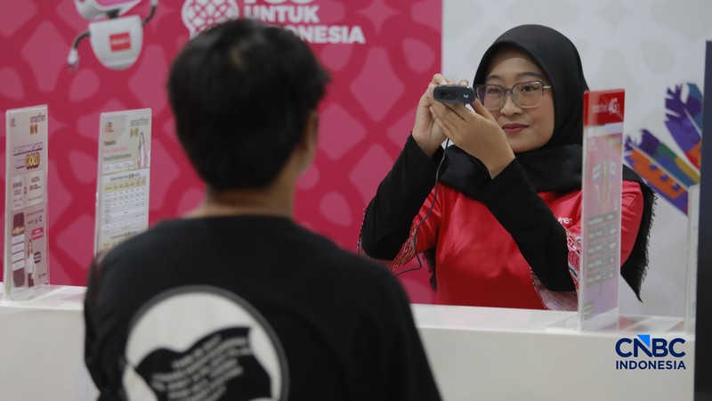 Seorang pengunjung melakukan sistem registrasi pelanggan layanan telekomunikasi berbasis data biometrik dengan dukungan teknologi pengenalan wajah di counter Smartfren, Mall Ambasador, Jakarta, Rabu, (1/7/2026). (CNBC Indonesia/Muhammad Sabki)