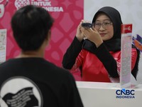 Seorang pengunjung melakukan sistem registrasi pelanggan layanan telekomunikasi berbasis data biometrik dengan dukungan teknologi pengenalan wajah di counter Smartfren, Mall Ambasador, Jakarta, Rabu, (1/7/2026). (CNBC Indonesia/Muhammad Sabki)