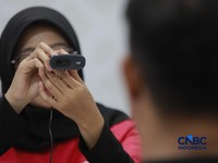 Seorang pengunjung melakukan sistem registrasi pelanggan layanan telekomunikasi berbasis data biometrik dengan dukungan teknologi pengenalan wajah di counter Smartfren, Mall Ambasador, Jakarta, Rabu, (1/7/2026). (CNBC Indonesia/Muhammad Sabki)