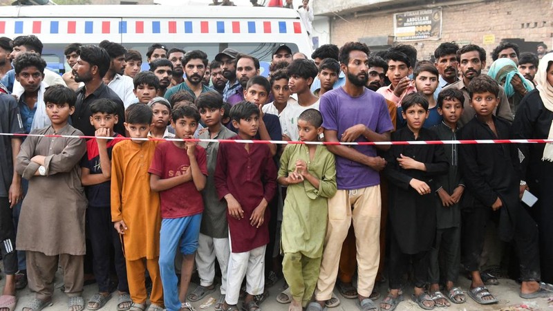 Warga berkumpul di lokasi tempat anak-anak dilaporkan meninggal setelah atap pusat bimbingan belajar runtuh, di Lahore, Pakistan, 30 Juni 2026.