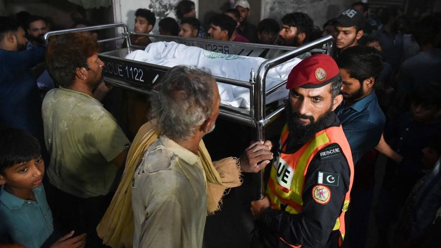 Warga dan petugas penyelamat membawa jenazah seorang anak ke rumah, yang meninggal setelah atap pusat bimbingan belajar runtuh, di Lahore, Pakistan, 30 Juni 2026.