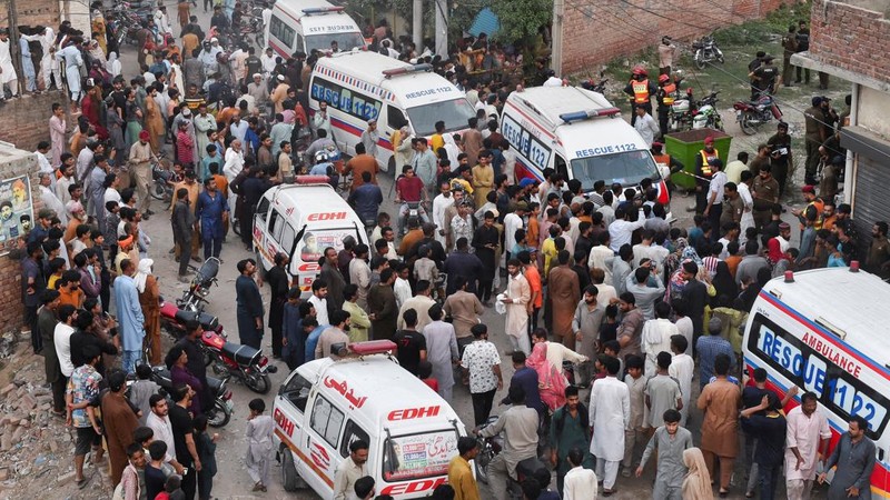 Warga setempat dan ambulans penyelamat terparkir di lokasi tempat anak-anak dilaporkan meninggal setelah atap pusat bimbingan belajar runtuh, di Lahore, Pakistan, 30 Juni 2026.