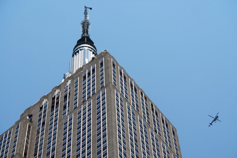 Dua orang membentangkan spanduk di puncak Gedung Empire State di distrik Manhattan, New York, AS, Rabu (1/7/2026). (ABC Affiliate WABC/Handout via REUTERS)