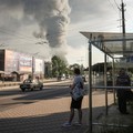 Orang-orang berdiri di halte bus saat asap mengepul setelah serangan rudal dan pesawat tak berawak Rusia, di tengah serangan Rusia terhadap Ukraina, di Kyiv, Ukraina, 2 Juli 2026. (REUTERS/Alina Smutko)