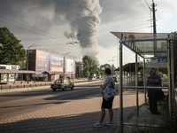 Orang-orang berdiri di halte bus saat asap mengepul setelah serangan rudal dan pesawat tak berawak Rusia, di tengah serangan Rusia terhadap Ukraina, di Kyiv, Ukraina, 2 Juli 2026. (REUTERS/Alina Smutko)