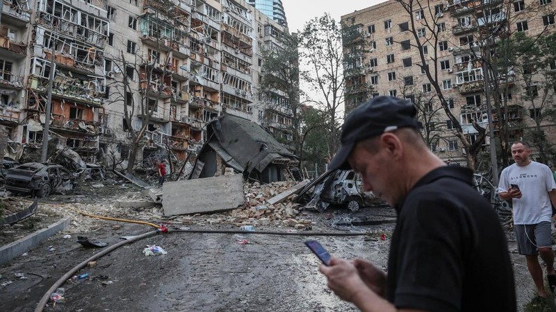 Orang-orang berkumpul di dekat bangunan yang rusak akibat serangan rudal dan pesawat tak berawak Rusia semalam, di tengah serangan Rusia terhadap Ukraina, di Kyiv, Ukraina, 2 Juli 2026.