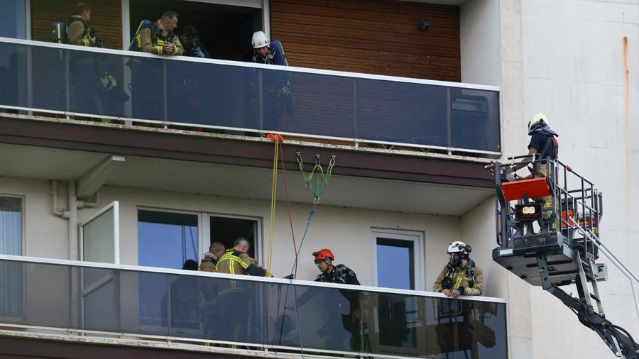 Para petugas penyelamat bekerja di lokasi kebakaran di sebuah gedung perumahan di Antwerp, Belgia, 1 Juli 2026. (REUTERS/Yves Herman)