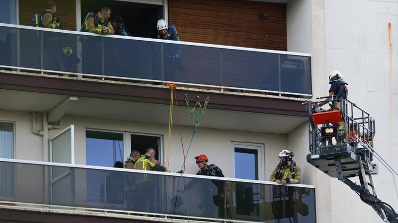 Para petugas penyelamat bekerja di lokasi kebakaran di sebuah gedung perumahan di Antwerp, Belgia, 1 Juli 2026. (REUTERS/Yves Herman)