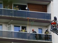 Para petugas penyelamat bekerja di lokasi kebakaran di sebuah gedung perumahan di Antwerp, Belgia, 1 Juli 2026. (REUTERS/Yves Herman)