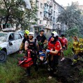 Para sukarelawan, paramedis, dan petugas penyelamat membawa seorang warga yang terluka di lokasi gedung apartemen yang rusak akibat serangan rudal dan pesawat tak berawak Rusia semalam, di tengah serangan Rusia terhadap Ukraina, di Kyiv, Ukraina, 2 J