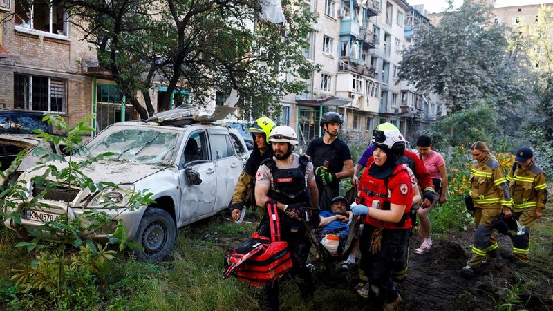 Para sukarelawan, paramedis, dan petugas penyelamat membawa seorang warga yang terluka di lokasi gedung apartemen yang rusak akibat serangan rudal dan pesawat tak berawak Rusia semalam, di tengah serangan Rusia terhadap Ukraina, di Kyiv, Ukraina, 2 Juli 2026.
