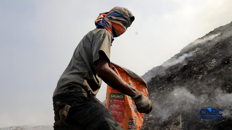 Seorang terlihat mengumpulkan sisa-sisa besi bekas dari gunungan sampah yang sebagian telah hangus terbakar ditengah kebakaran melanda TPA Jatiwaringin, Kabupaten Tangerang, Banten, Kamis, (2/7/2026).
