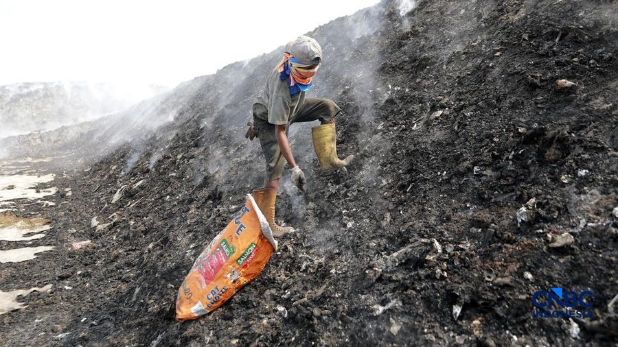 Seorang terlihat mengumpulkan sisa-sisa besi bekas dari gunungan sampah yang sebagian telah hangus terbakar ditengah kebakaran melanda TPA Jatiwaringin, Kabupaten Tangerang, Banten, Kamis, (2/7/2026).