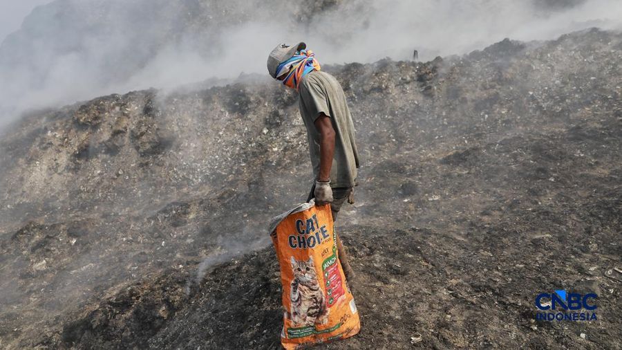 Seorang terlihat mengumpulkan sisa-sisa besi bekas dari gunungan sampah yang sebagian telah hangus terbakar ditengah kebakaran melanda TPA Jatiwaringin, Kabupaten Tangerang, Banten, Kamis, (2/7/2026).