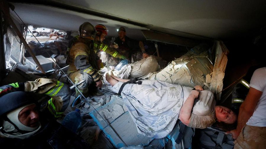Tim penyelamat membawa seorang wanita yang ditemukan di bawah reruntuhan di dalam gedung apartemen yang terkena serangan rudal dan pesawat tak berawak Rusia semalam, di tengah serangan Rusia terhadap Ukraina, di Kyiv, Ukraina, 2 Juli 2026.