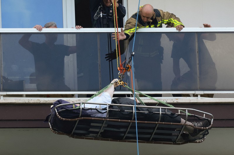 Para petugas penyelamat bekerja di lokasi kebakaran di sebuah gedung perumahan di Antwerp, Belgia, 1 Juli 2026. (REUTERS/Yves Herman)