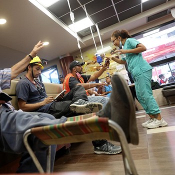 Orang-orang menerima perawatan di klinik hewan darurat dan tempat triase untuk manusia di dalam restoran McDonald's, setelah gempa bumi, di La Guaira, Venezuela, 2 Juli 2026. (REUTERS/Ricardo Arduengo)