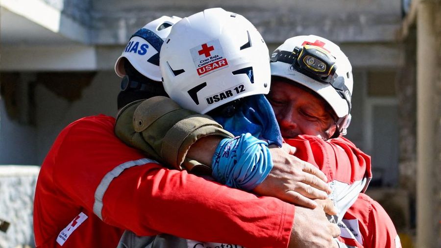 Para petugas penyelamat saling berpelukan setelah menarik keluar korban selamat Hernan Alberto Gil, yang terjebak selama lebih dari seminggu setelah gempa bumi 24 Juni, dari reruntuhan pusat perbelanjaan di La Guaira, Venezuela, 2 Juli 2026.