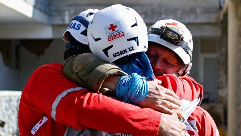 Para petugas penyelamat saling berpelukan setelah menarik keluar korban selamat Hernan Alberto Gil, yang terjebak selama lebih dari seminggu setelah gempa bumi 24 Juni, dari reruntuhan pusat perbelanjaan di La Guaira, Venezuela, 2 Juli 2026.