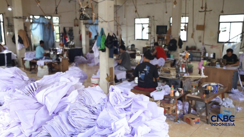Pekerja menyelesaikan produksi pakain sekolah di konveksi rumahan kawasan Jakarta, Jumat (3/7/2026). (CNBC Indonesia/Tri Susilo)