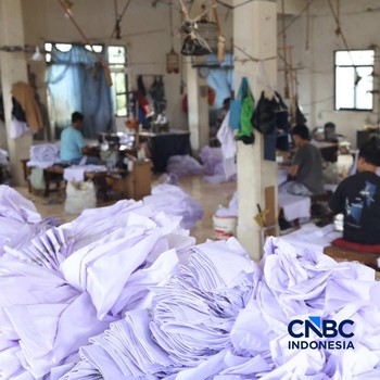 Pekerja menyelesaikan produksi pakain sekolah di konveksi rumahan kawasan Jakarta, Jumat (3/7/2026). (CNBC Indonesia/Tri Susilo)