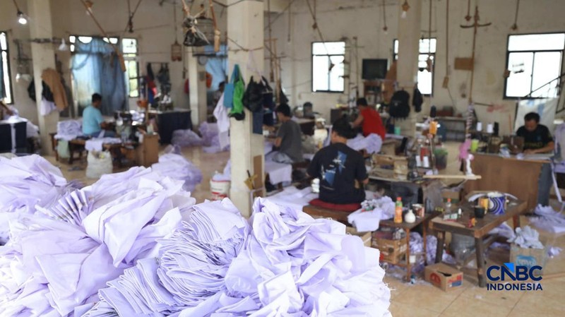 Pekerja menyelesaikan produksi pakain sekolah di konveksi rumahan kawasan Jakarta, Jumat (3/7/2026).