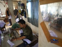 Pekerja menyelesaikan produksi pakain sekolah di konveksi rumahan kawasan Jakarta, Jumat (3/7/2026). (CNBC Indonesia/Tri Susilo)