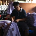 Pekerja menyelesaikan produksi pakain sekolah di konveksi rumahan kawasan Jakarta, Jumat (3/7/2026). (CNBC Indonesia/Tri Susilo)