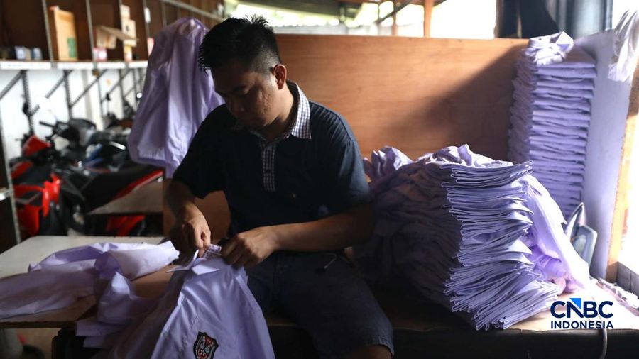 Pekerja menyelesaikan produksi pakain sekolah di konveksi rumahan kawasan Jakarta, Jumat (3/7/2026). (CNBC Indonesia/Tri Susilo)