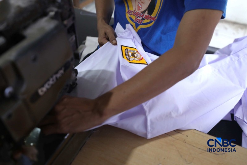 Pekerja menyelesaikan produksi pakain sekolah di konveksi rumahan kawasan Jakarta, Jumat (3/7/2026). (CNBC Indonesia/Tri Susilo)