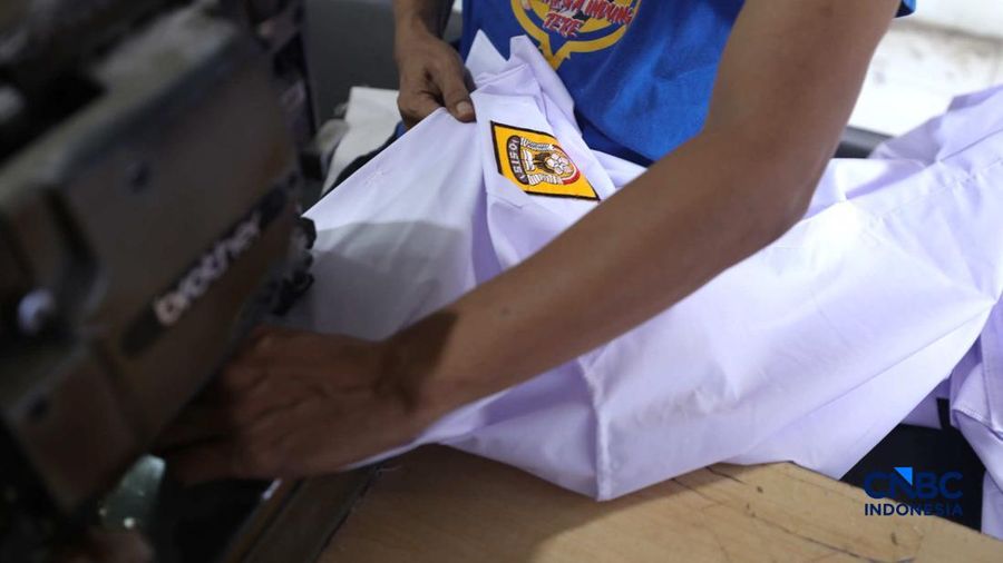 Pekerja menyelesaikan produksi pakain sekolah di konveksi rumahan kawasan Jakarta, Jumat (3/7/2026).