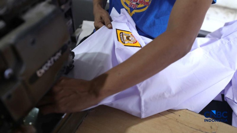 Pekerja menyelesaikan produksi pakain sekolah di konveksi rumahan kawasan Jakarta, Jumat (3/7/2026).