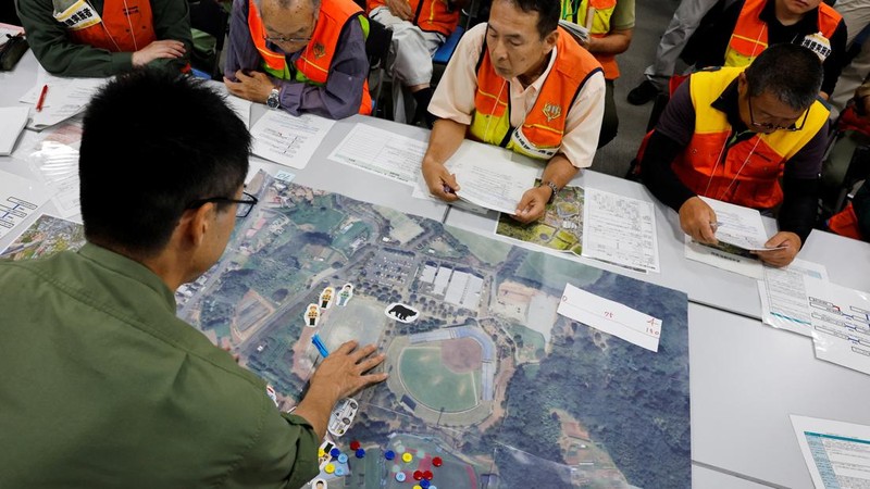 Seorang peserta menjelaskan prosedur respons terhadap serangan beruang kepada para pemburu selama latihan respons darurat yang mensimulasikan serangan beruang, di Isehara, Prefektur Kanagawa, Jepang, 3 Juli 2026.