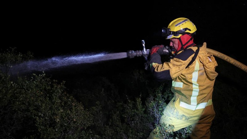 Seorang petugas pemadam kebakaran menyemprotkan air saat kebakaran hutan berkobar di Pouzols-Minervois dekat Narbonne, Prancis, 3 Juli 2026.