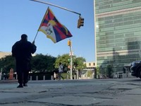 Seorang pria yang diidentifikasi oleh Voice of Tibet, sebuah media yang mewakili warga Tibet di pengasingan, sebagai aktivis Tibet Lobga Rangzen, berjalan sambil membawa bendera Tibet di dekat markas besar Perserikatan Bangsa-Bangsa, sebelum membakar
