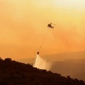 People look on as flames and smoke from a wildfire rise near Calonge, Spain, July 4, 2026. REUTERS/Bruna Casas     TPX IMAGES OF THE DAY