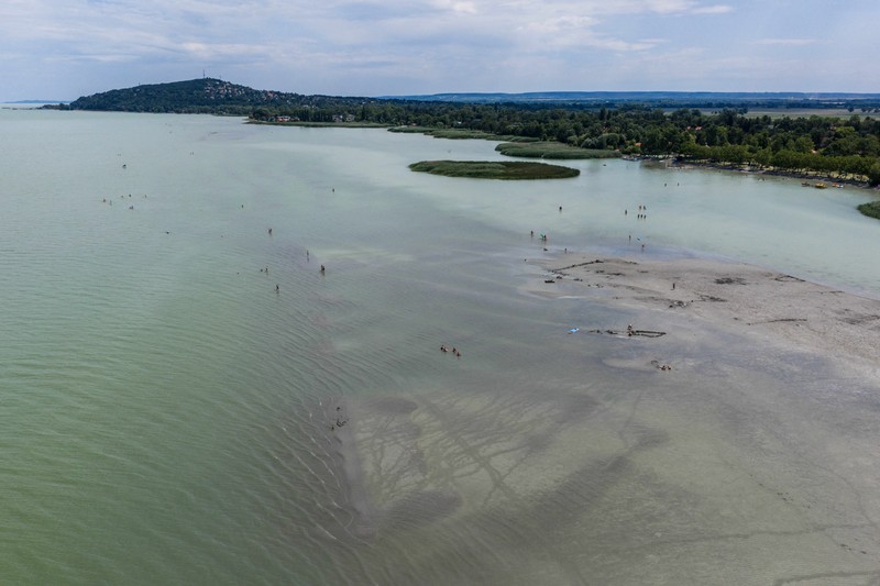 A drone view shows people walking on an exposed sandbank locally known as