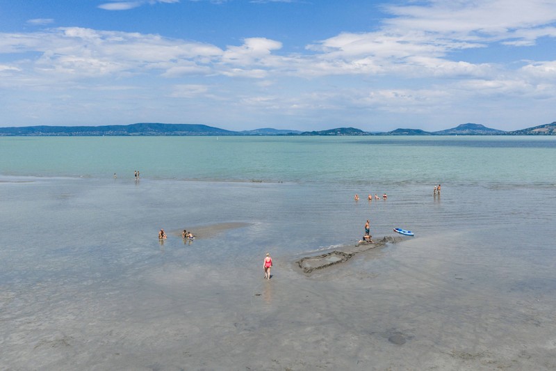 A drone view shows people walking on an exposed sandbank locally known as