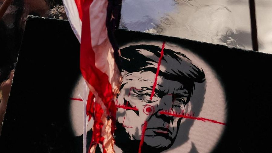Bendera Amerika yang dibakar oleh para pelayat, berkobar di dekat papan bertuliskan Presiden AS Donald Trump, saat orang-orang berkumpul pada hari prosesi pemakaman mendiang Pemimpin Tertinggi Iran Ayatollah Ali Khamenei, yang tewas pada 28 Februari dalam serangan udara Israel dan AS, di Teheran, Iran, 6 Juli 2026.