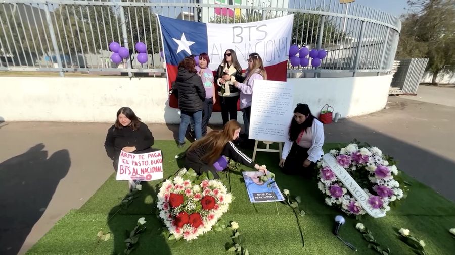 BTS berkumpul di depan Istana Kepresidenan Palacio de la Moneda, Cile, pada Jumat (3/7), untuk memprotes pembatalan konser grup K-pop tersebut yang sedianya digelar di Stadion Nasional, Santiago, pada Oktober mendatang. (Tangkapan Layar Video Reuters