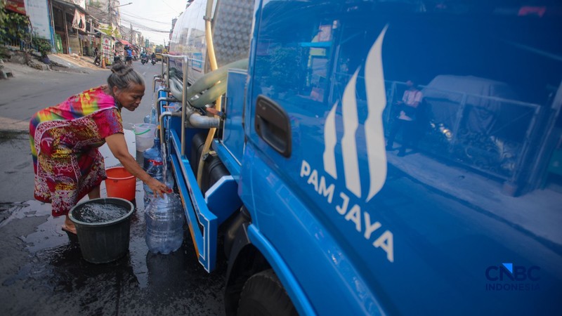 Warga mengambil air bersih dari mobil layanan bantuan air bersih di Jalan H Mawar, Sunter Jaya, Tanjung Priok, Jakarta Utara, Senin (6/7/2026). (CNBC Indonesia/Faisal Rahman)