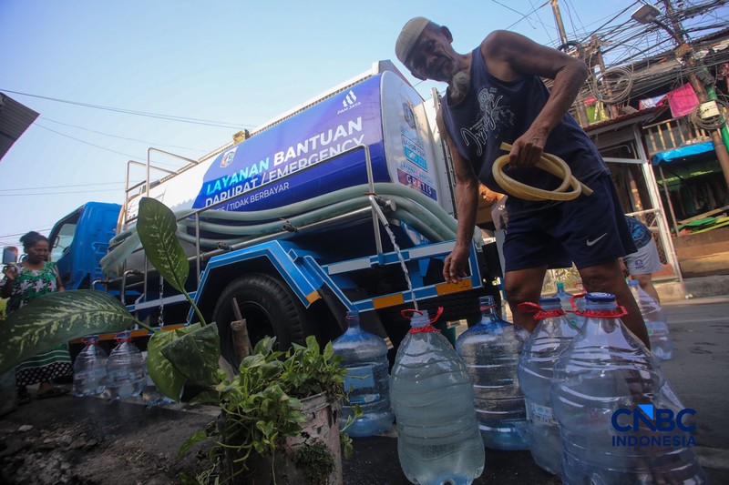 Warga mengambil air bersih dari mobil layanan bantuan air bersih di Jalan H Mawar, Sunter Jaya, Tanjung Priok, Jakarta Utara, Senin (6/7/2026). (CNBC Indonesia/Faisal Rahman)