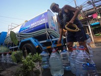 Warga mengambil air bersih dari mobil layanan bantuan air bersih di Jalan H Mawar, Sunter Jaya, Tanjung Priok, Jakarta Utara, Senin (6/7/2026). (CNBC Indonesia/Faisal Rahman)
