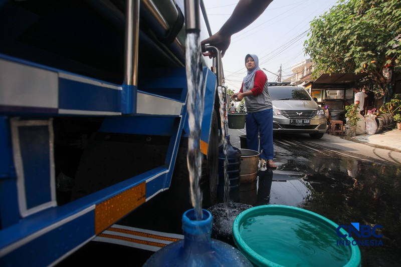 Warga mengambil air bersih dari mobil layanan bantuan air bersih di Jalan H Mawar, Sunter Jaya, Tanjung Priok, Jakarta Utara, Senin (6/7/2026). (CNBC Indonesia/Faisal Rahman)