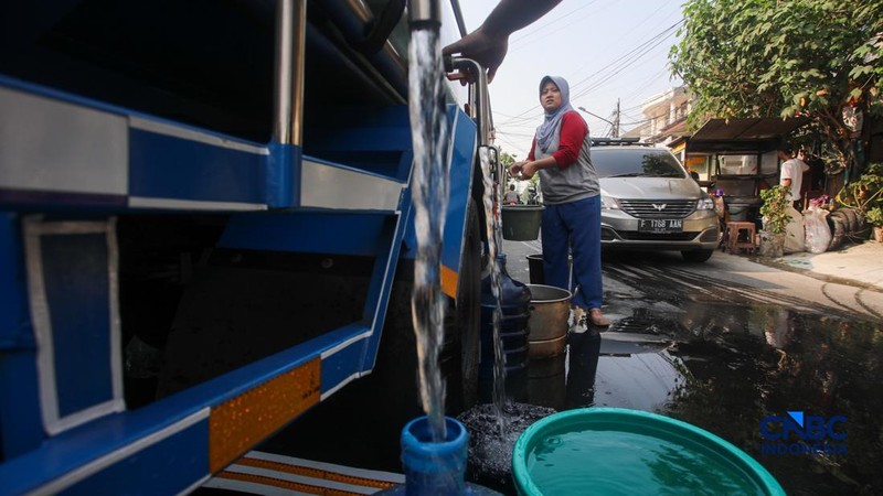 Warga mengambil air bersih dari mobil layanan bantuan air bersih di Jalan H Mawar, Sunter Jaya, Tanjung Priok, Jakarta Utara, Senin (6/7/2026).