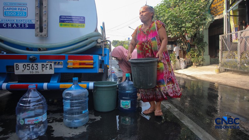 Warga mengambil air bersih dari mobil layanan bantuan air bersih di Jalan H Mawar, Sunter Jaya, Tanjung Priok, Jakarta Utara, Senin (6/7/2026). (CNBC Indonesia/Faisal Rahman)