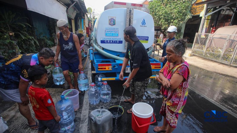 Warga mengambil air bersih dari mobil layanan bantuan air bersih di Jalan H Mawar, Sunter Jaya, Tanjung Priok, Jakarta Utara, Senin (6/7/2026). (CNBC Indonesia/Faisal Rahman)